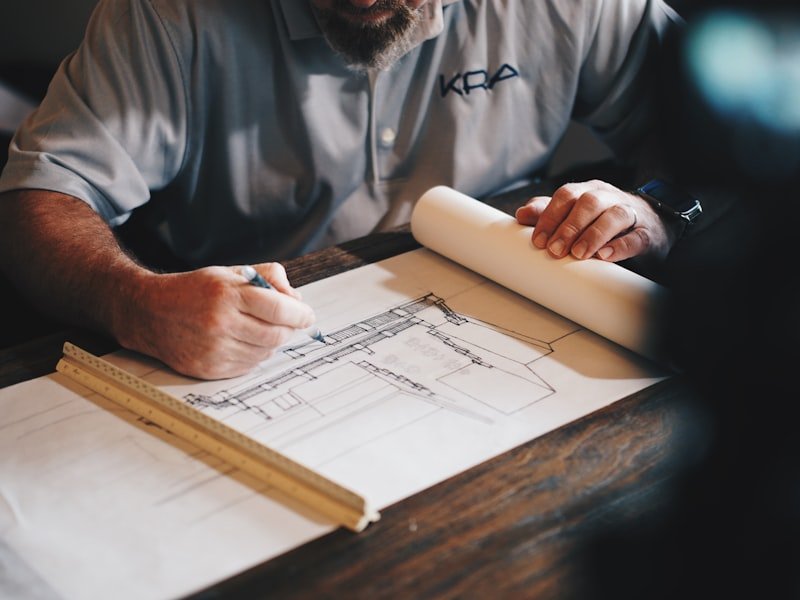 Designer working over measured architectural floor-plan drawings